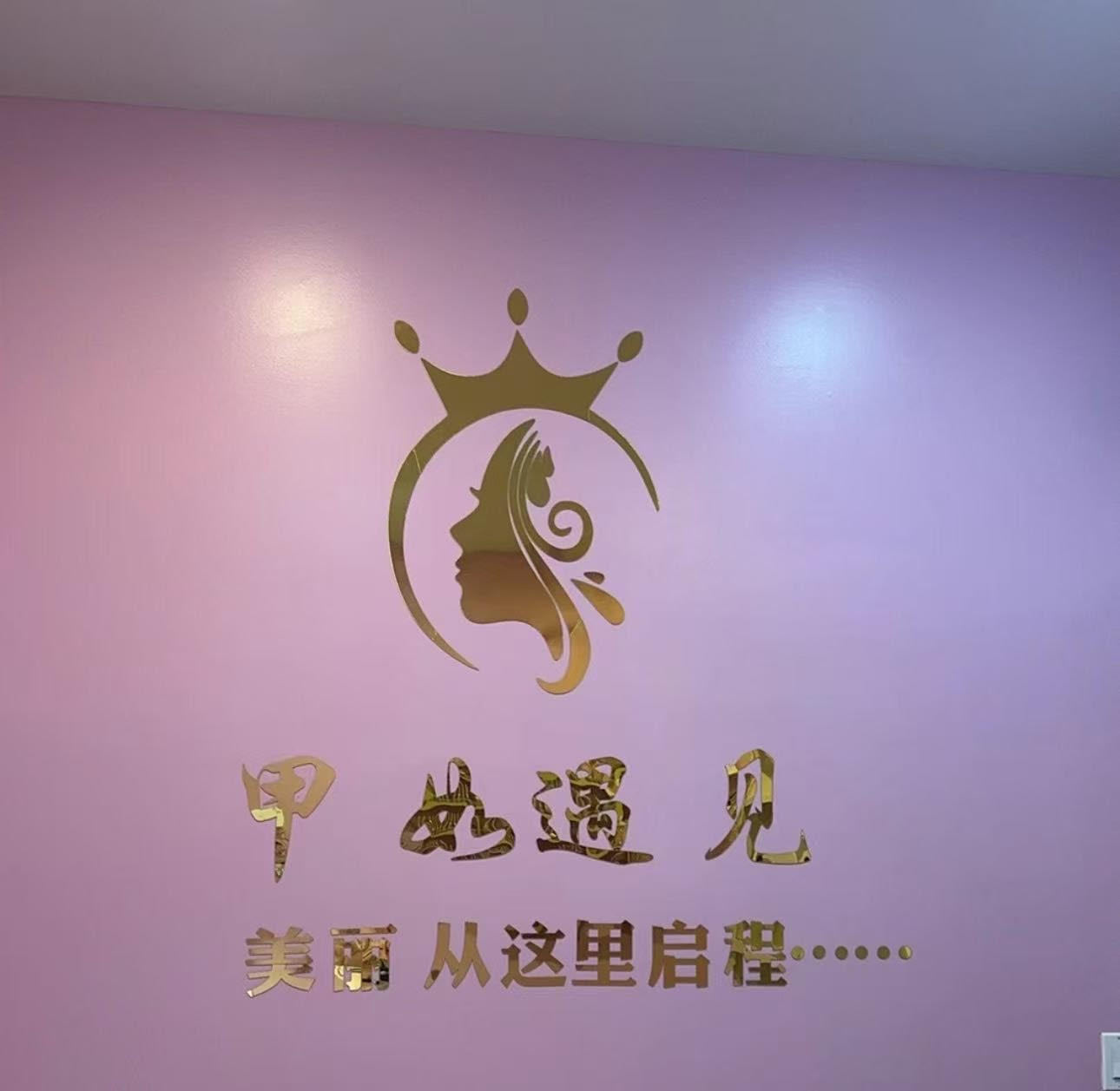 Gold logo and text on a pink wall